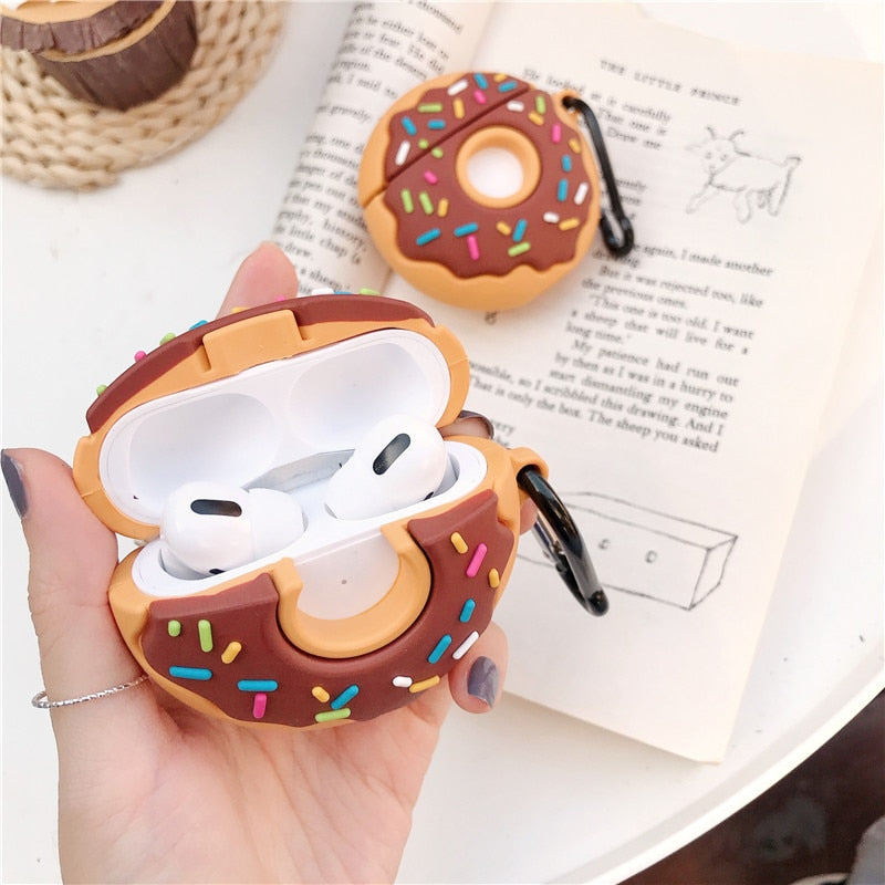 Donut-shaped airpod case held by a hand with a book in the background